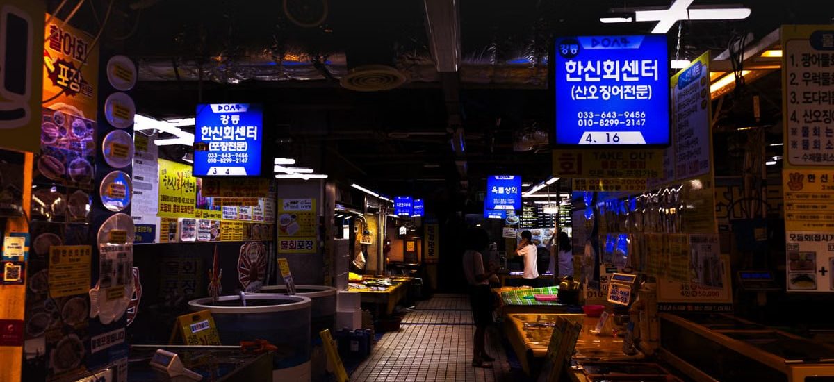 Explore the bustling atmosphere of a Korean fish market in Gangneung, filled with fresh seafood offerings.